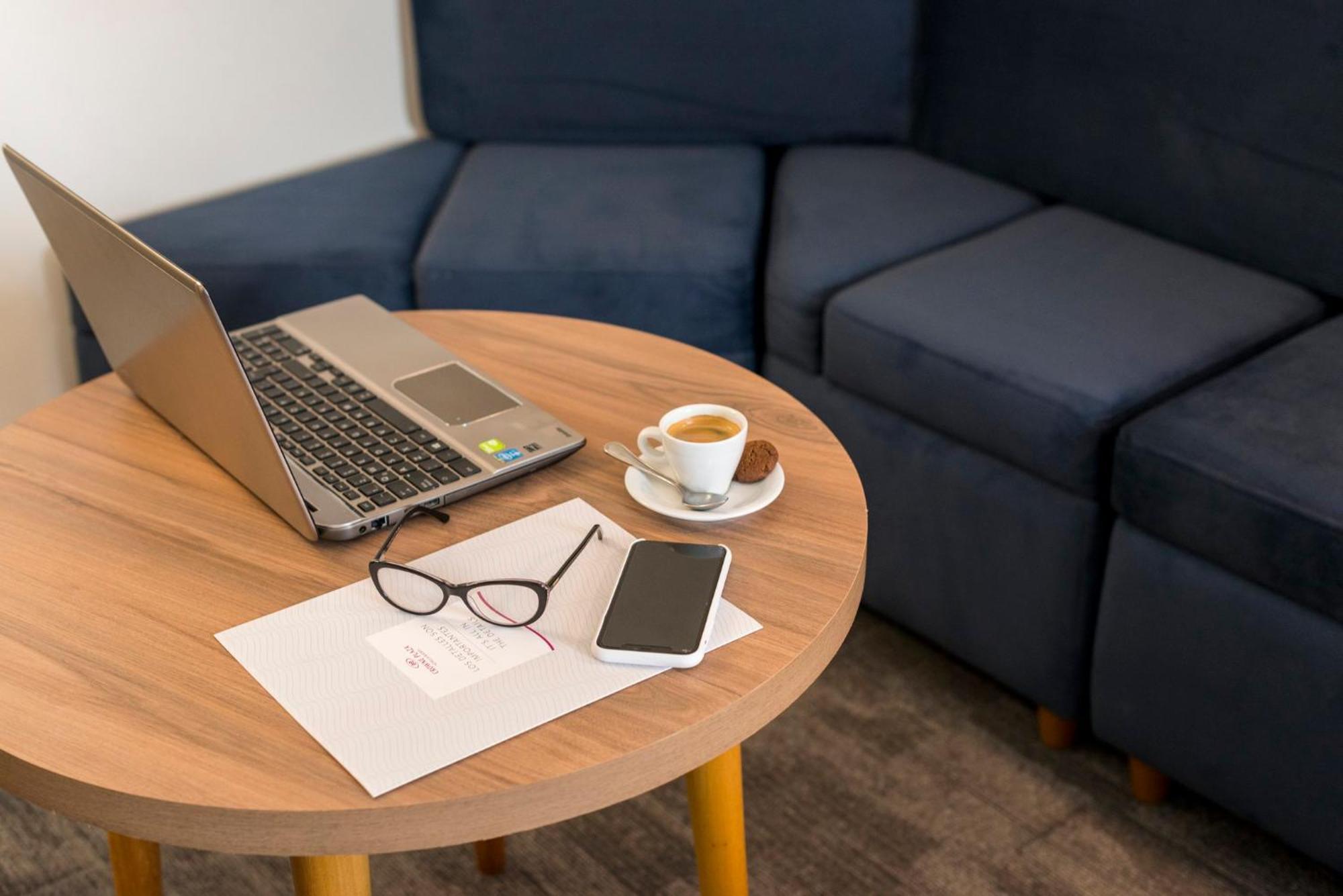 คราวน์ พลาซา ลิมา Hotel ภายนอก รูปภาพ A coffee table with a laptop, a cup of coffee, a mobile phone, and a pair of glasses